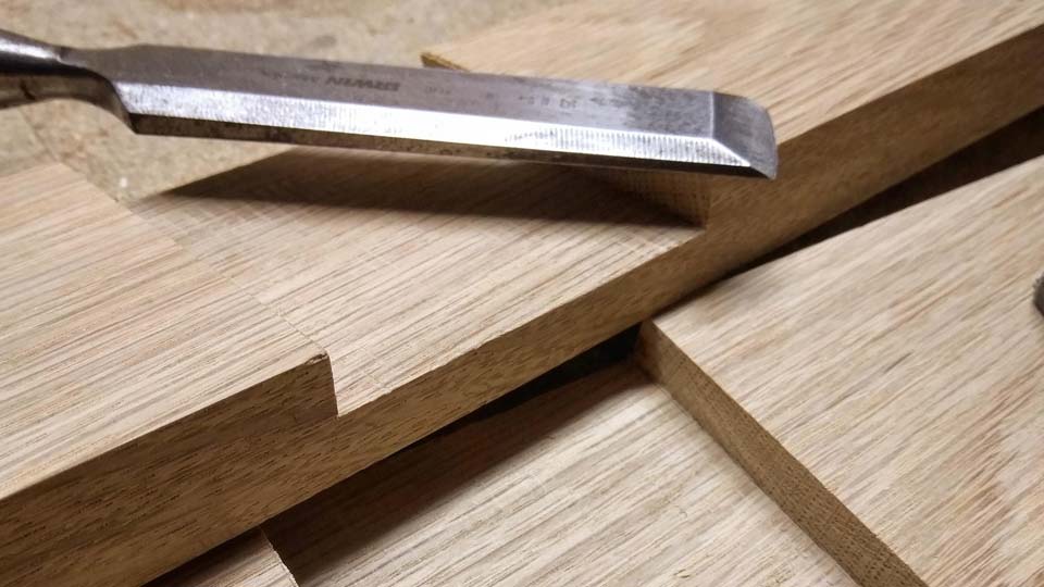 A chisel on top of two pieces of wood